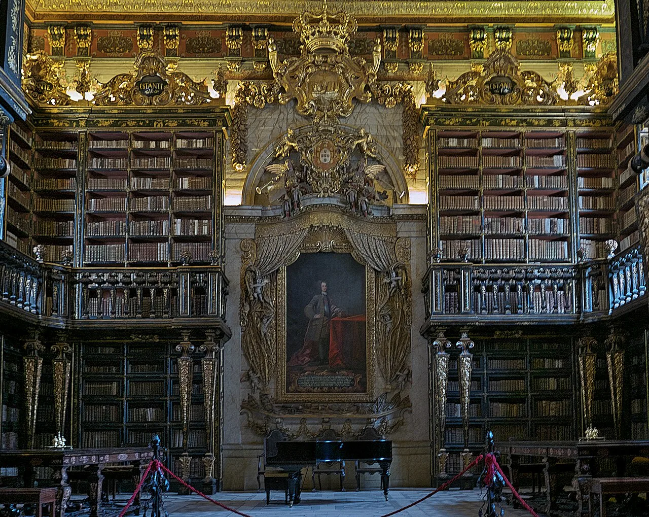 The gilded interior of the Biblioteca Joanina at the University of Coimbra, with the portrait of King João V.