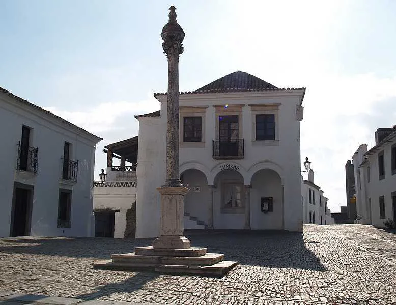 A pillory and whitewashed buildings on the main square of Monsaraz in the Alentejo.