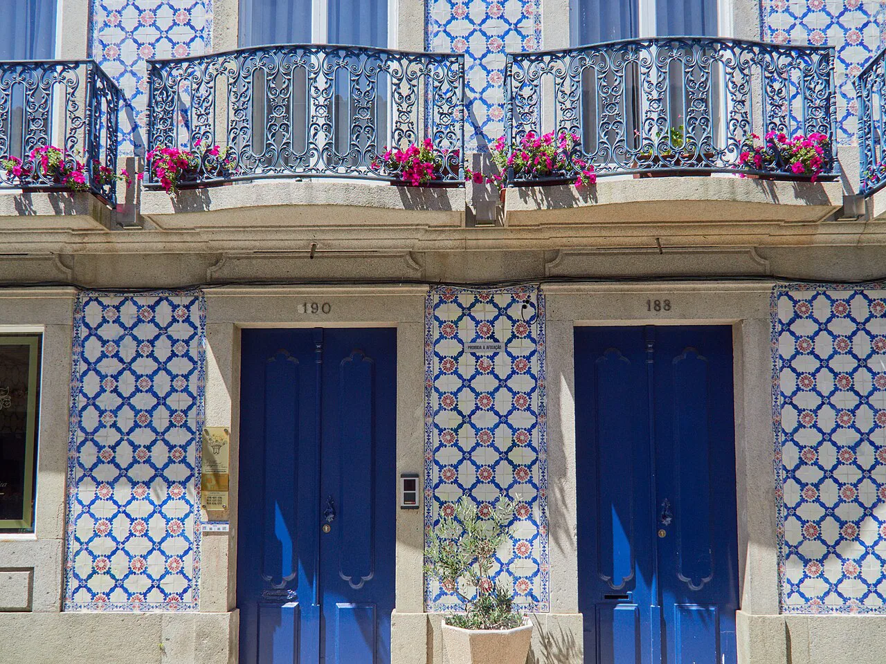 A building facade covered in traditional azulejos with two blue doors in Viana do Castelo.