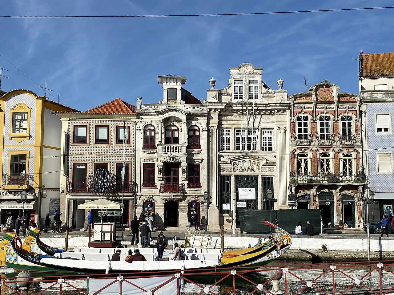 Moliceiro boats moored beside ornate façades on a canal in Aveiro.