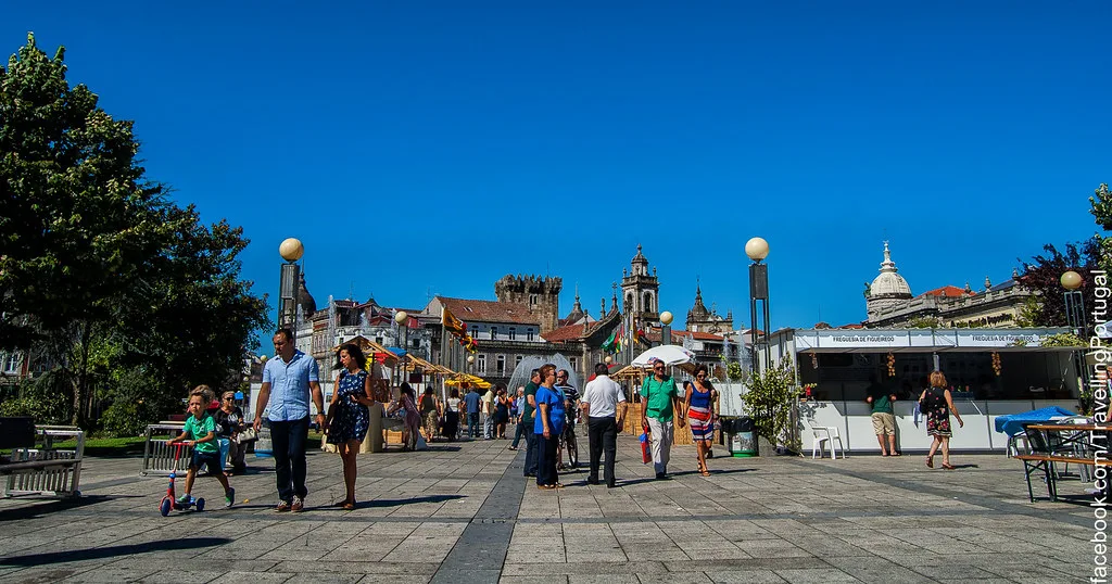 A paved square in central Braga with church towers on the skyline.