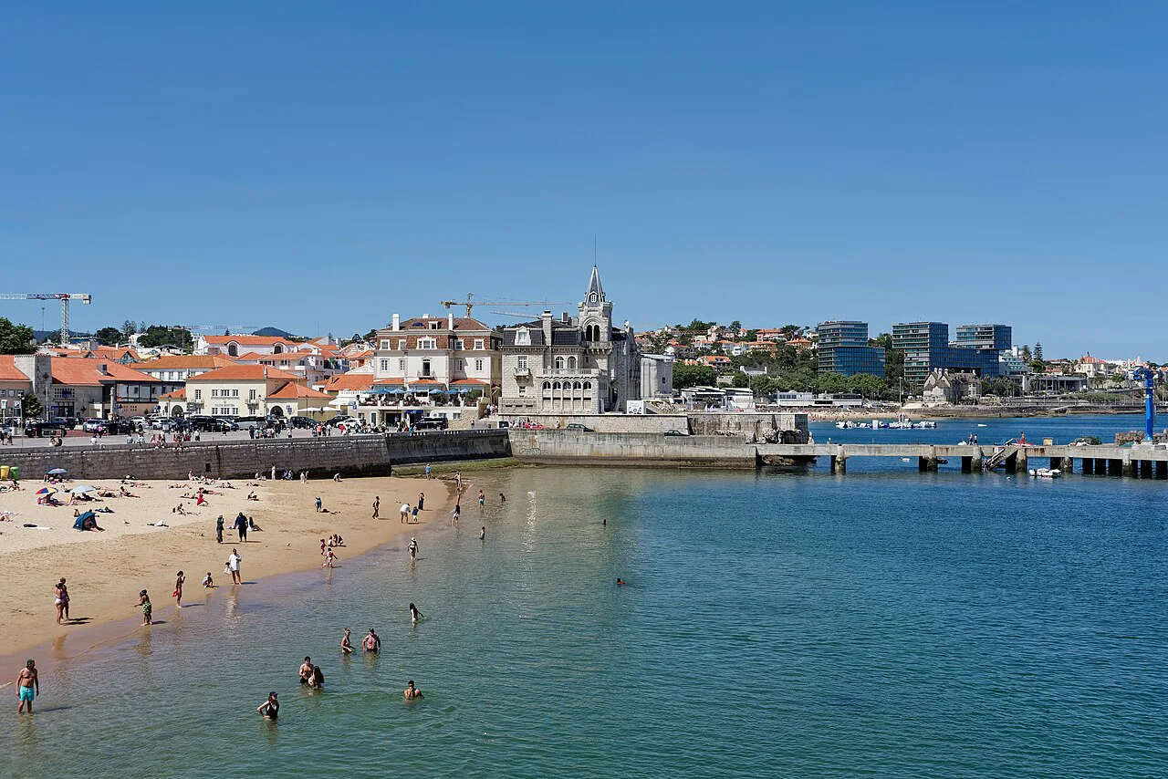 A beach on the Cascais seafront, with Palacete Seixas in the middle distance.