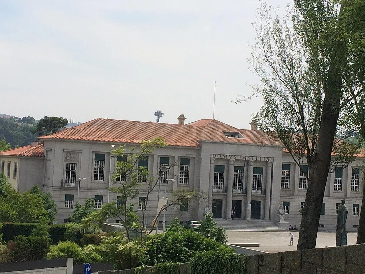 A civic building behind trees in Guimarães.
