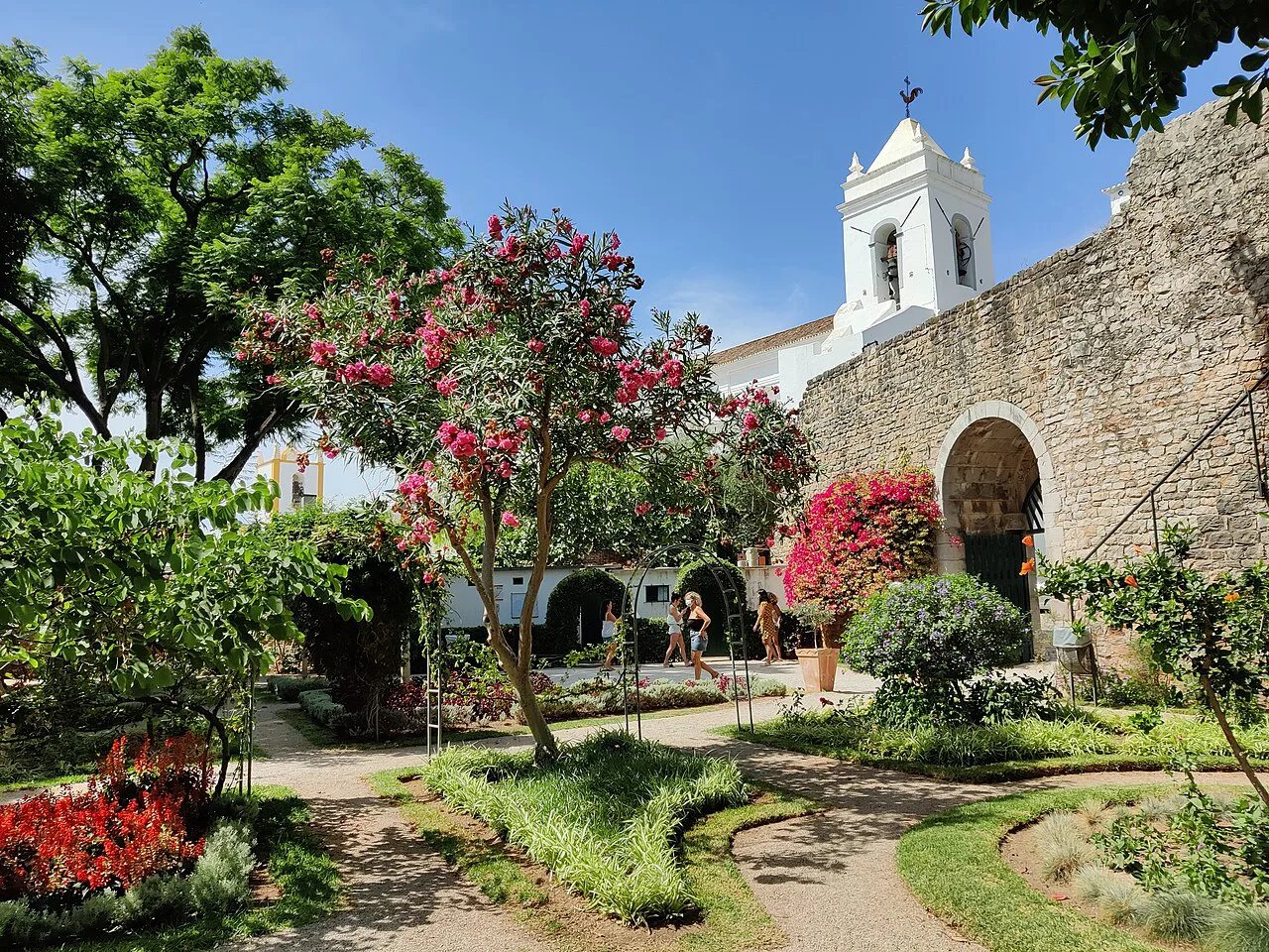 A garden beside a whitewashed church in Tavira.