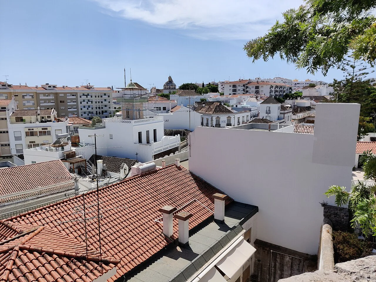 Tiled rooftops and white houses in Tavira seen from above.