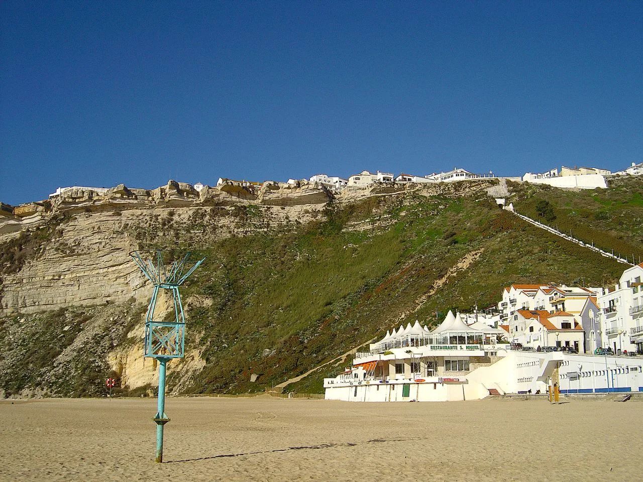 Nazaré beach with the cliff-top houses of the headland above.