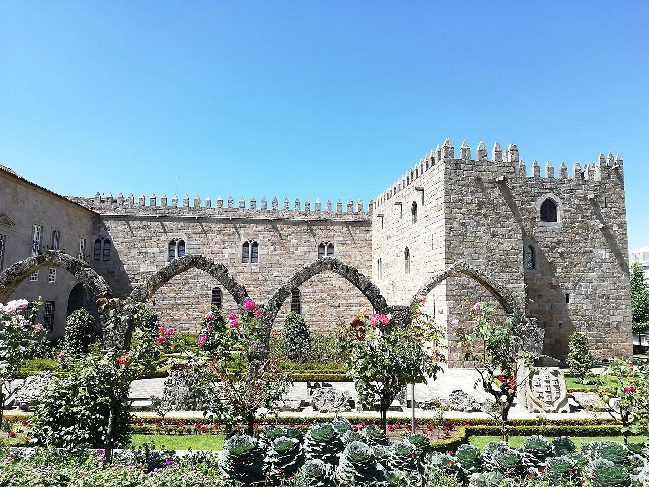 The medieval wing of the Paço Episcopal in Braga, behind a formal garden.