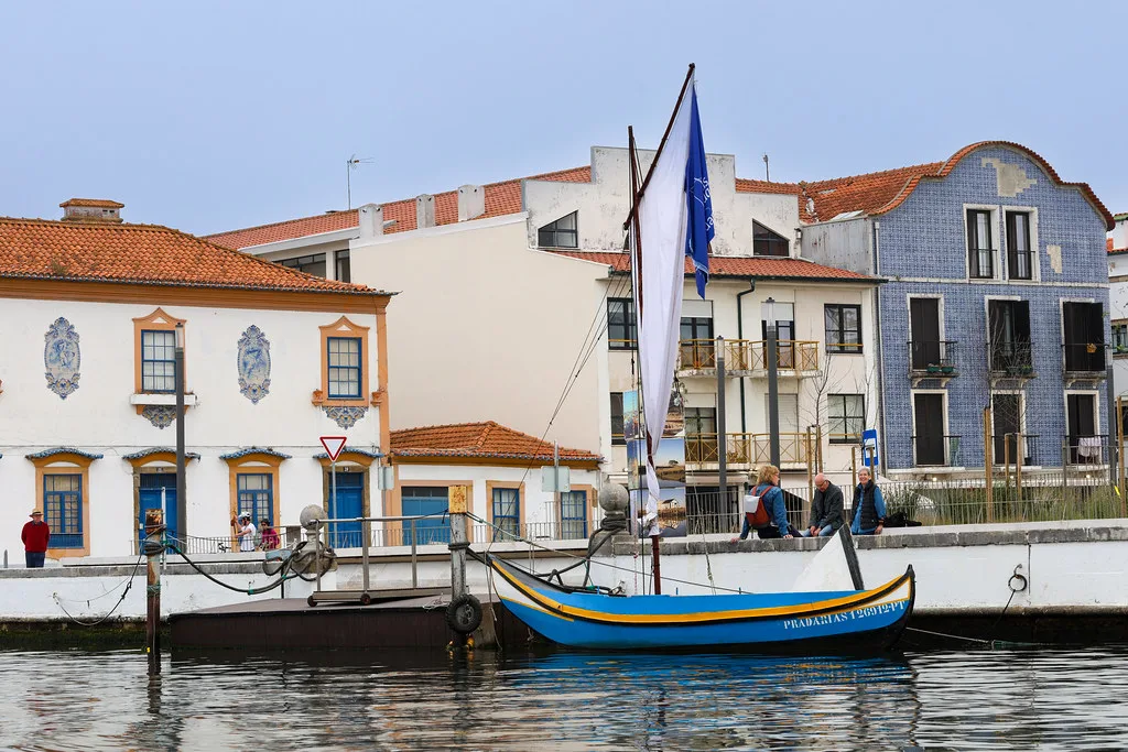 Tiled facades and a moliceiro boat on a canal in Aveiro.