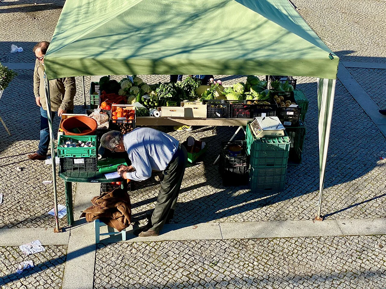 Fruit and vegetable stalls under awnings at the municipal market in Évora.