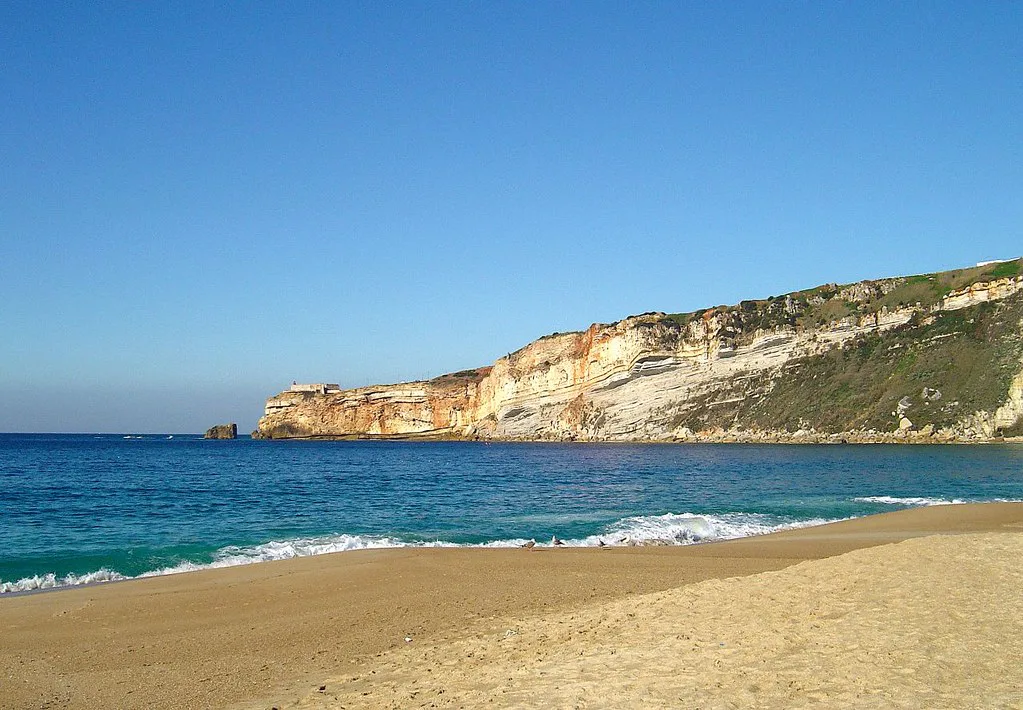 The sandy beach and cliffs at Nazaré.