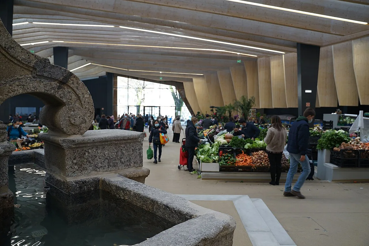 Shoppers among produce stalls inside the Mercado Municipal de Braga.