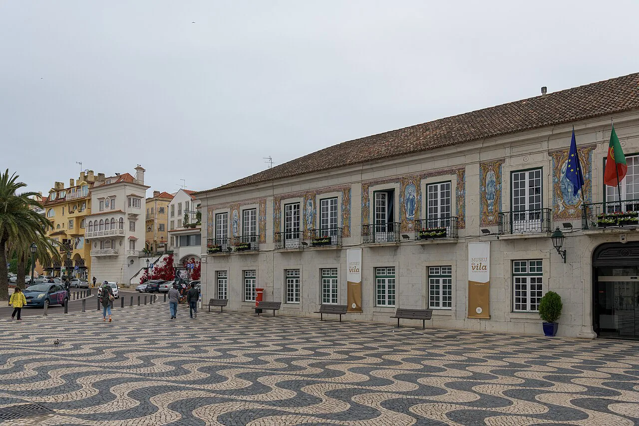 A square in central Cascais paved with patterned calçada stones.