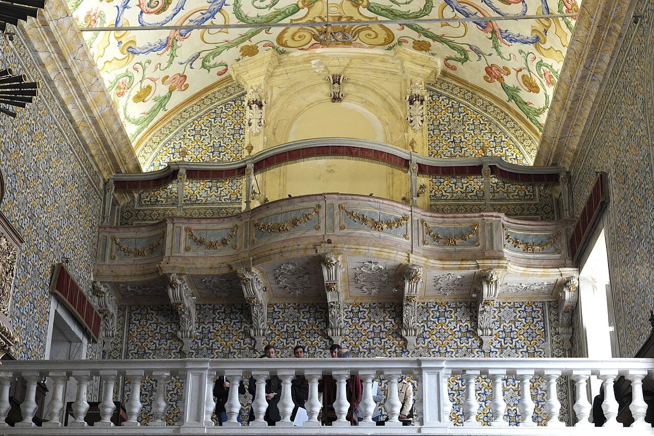 The organ gallery and azulejo walls inside the Capela de São Miguel at the University of Coimbra.