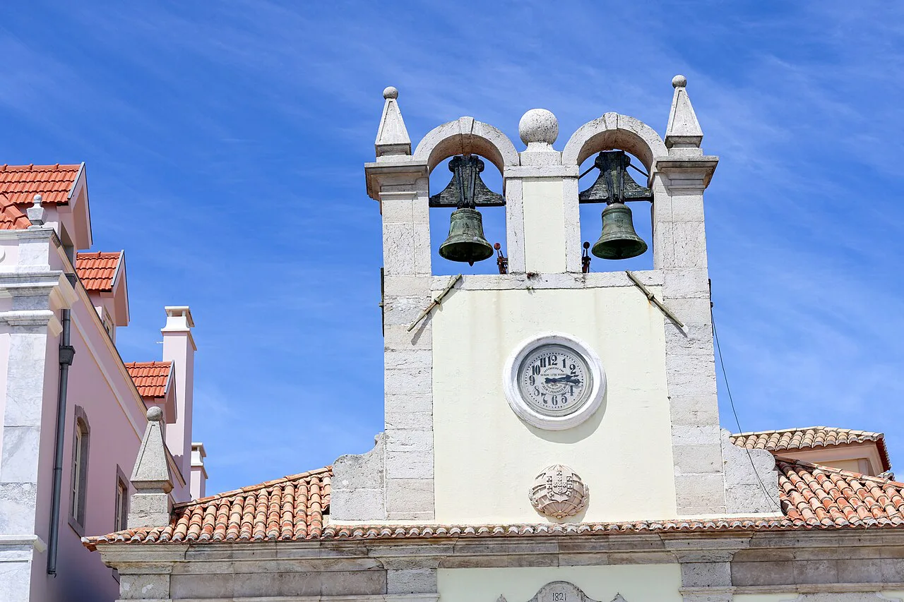 A white bell tower with a clock in Cascais.