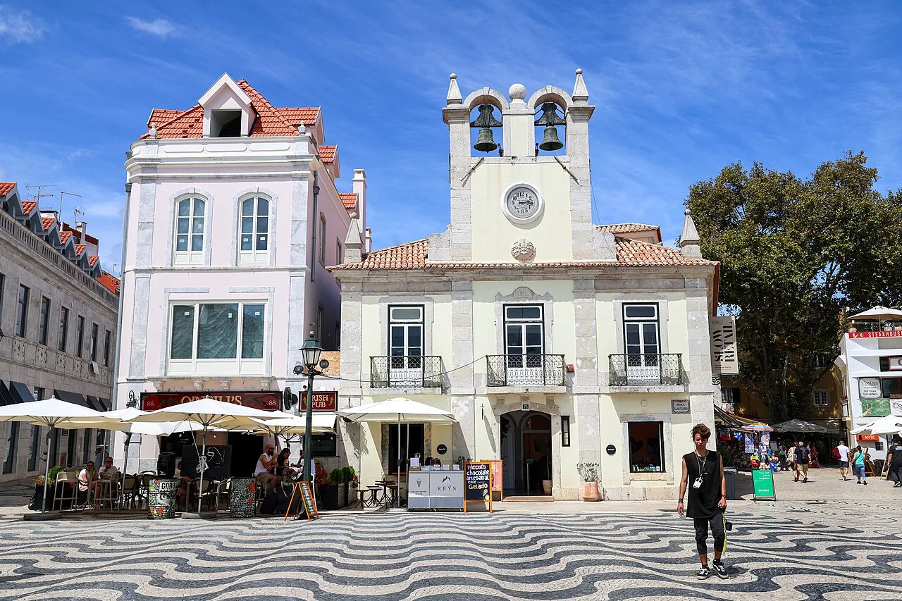 A calçada-paved square with café umbrellas in central Cascais.