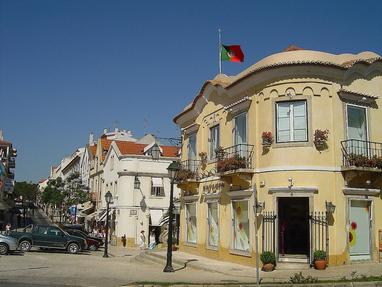A yellow corner building flying the Portuguese flag in Cascais.