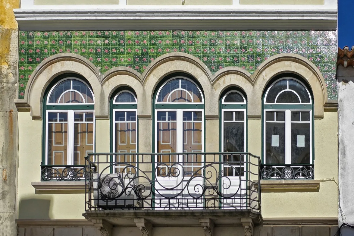 Tiled façade and wrought-iron balcony on a building in Rua Serpa Pinto, Tomar.