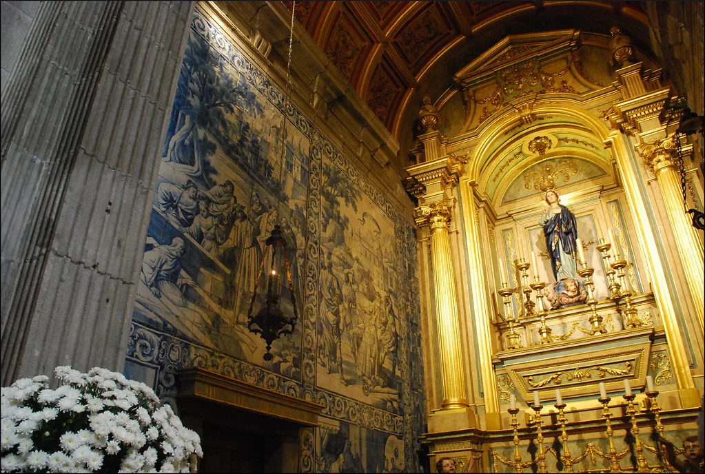 A gilded altar beside blue-and-white azulejo panels inside Braga Cathedral.