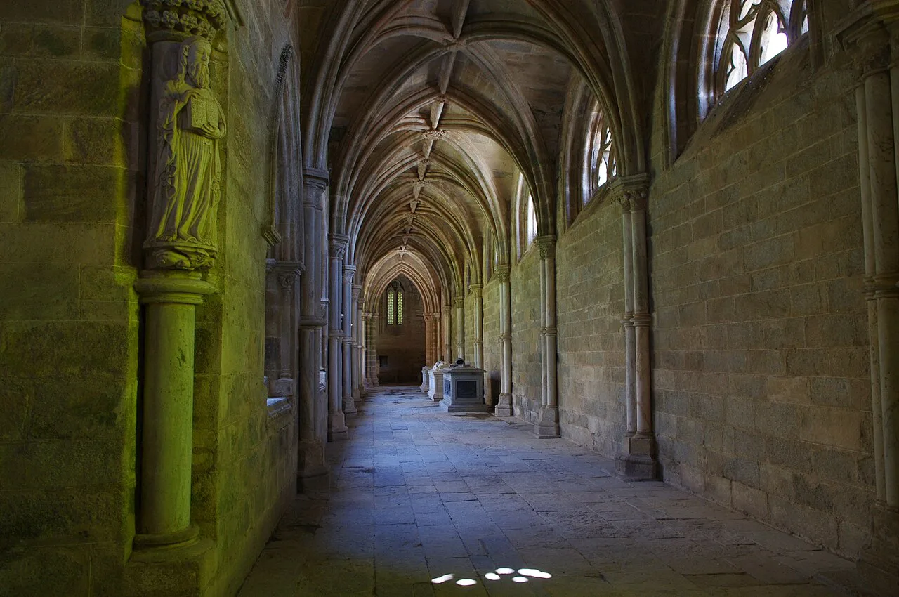 Gothic vaulting and stone walls inside the cloisters of Évora Cathedral.