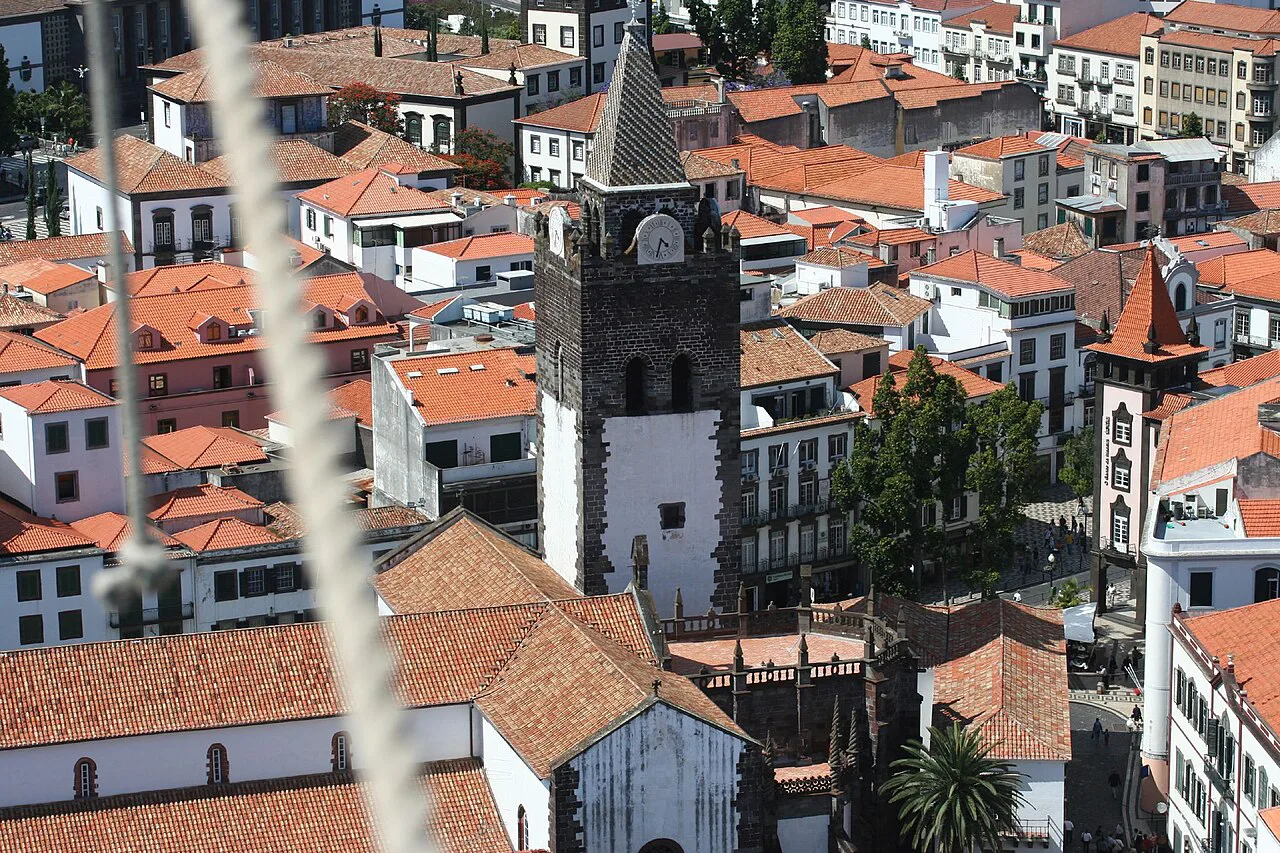 The tower of Funchal Cathedral rising above the city's rooftops.
