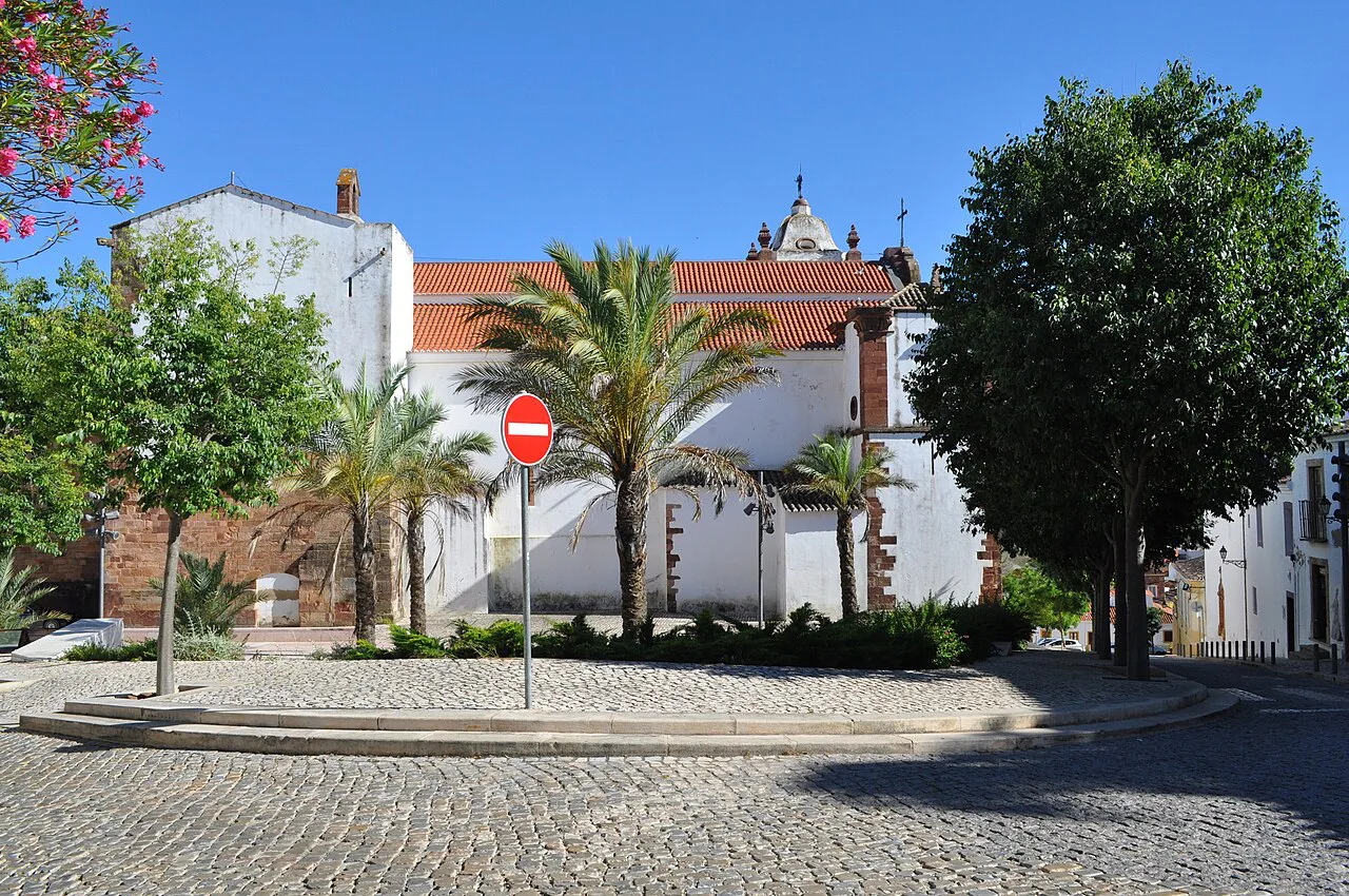 Whitewashed buildings and palms on the square by the Sé Catedral de Silves.