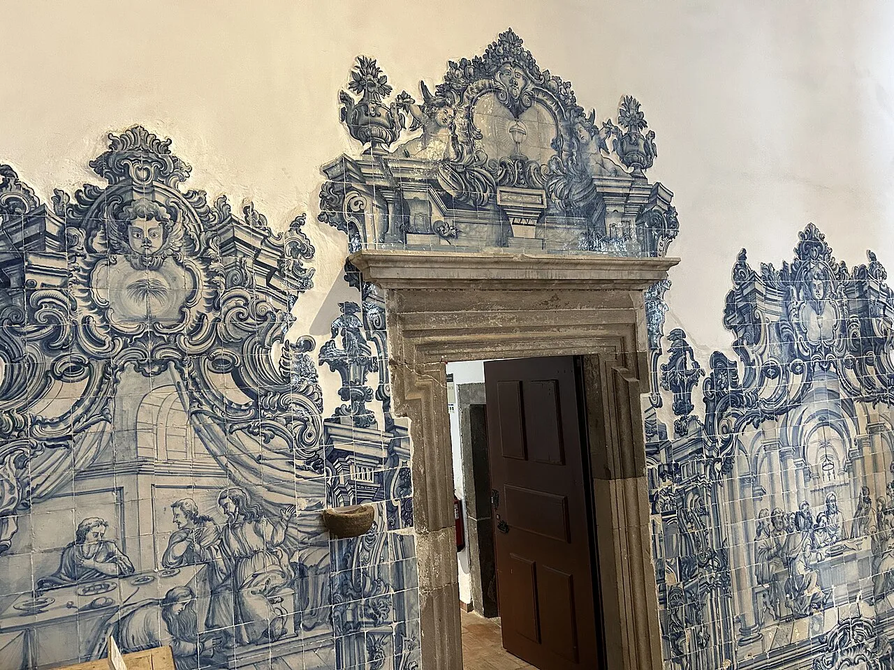 Blue-and-white azulejo panels around a doorway in the Misericórdia church in Tavira.