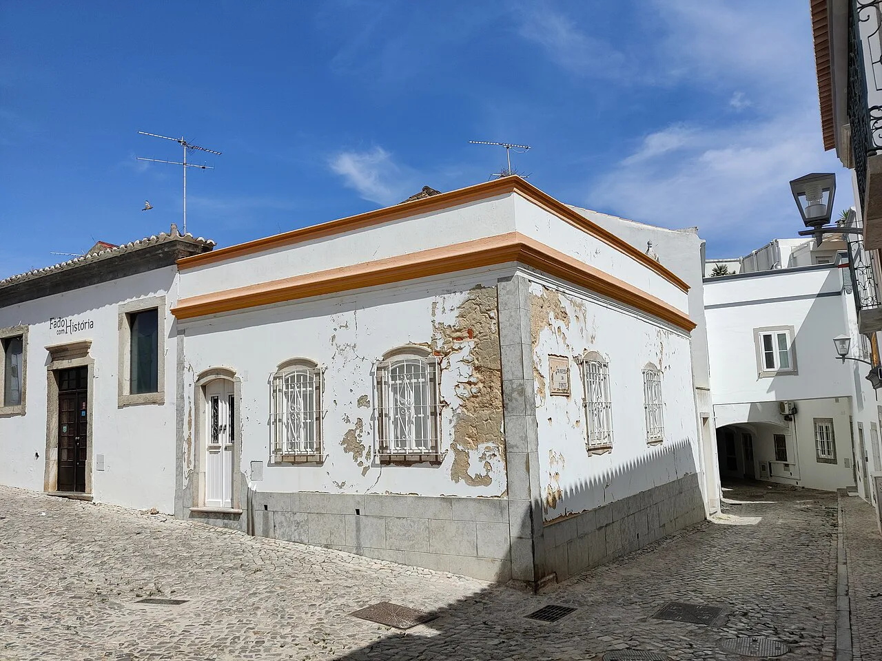 A whitewashed house on a cobbled street in Tavira.