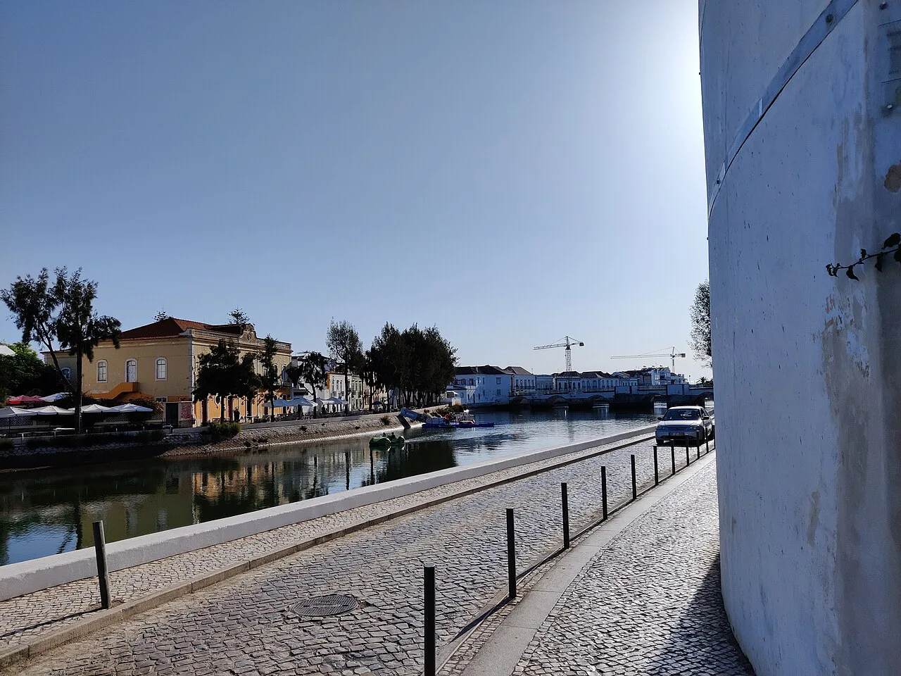 A paved riverside path beside the water in Tavira.