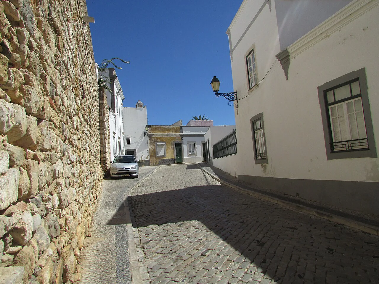 A cobbled street beside the old city wall in the old town of Faro.