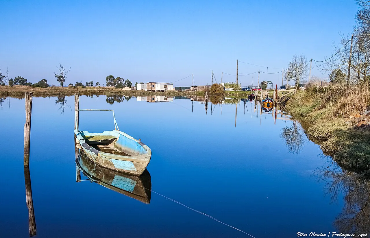 A small boat on still water in the Ria de Aveiro lagoon.