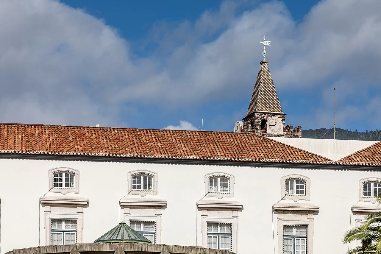 The tower of Funchal Cathedral (Sé do Funchal) rising above its tiled roofs.