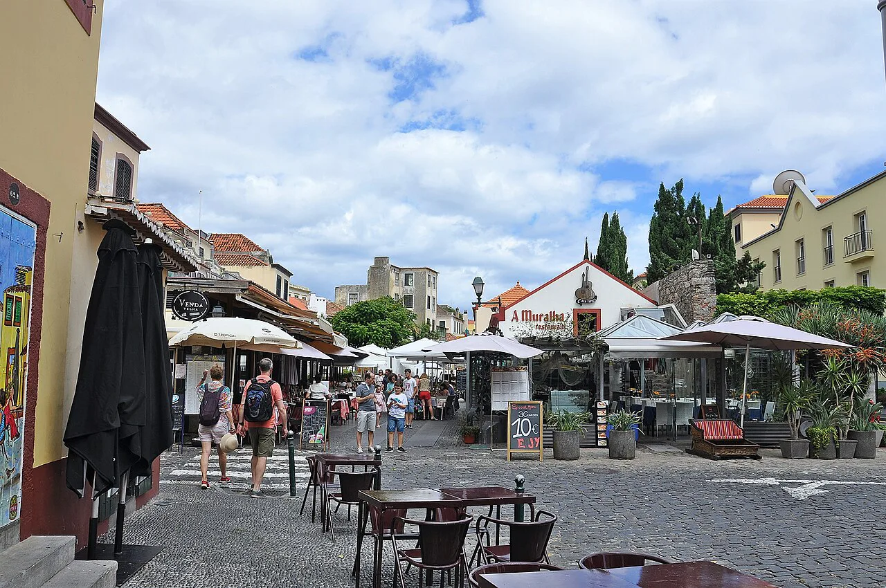 Café tables along Rua Dom Carlos I towards Largo do Corpo Santo in Funchal's historic centre.