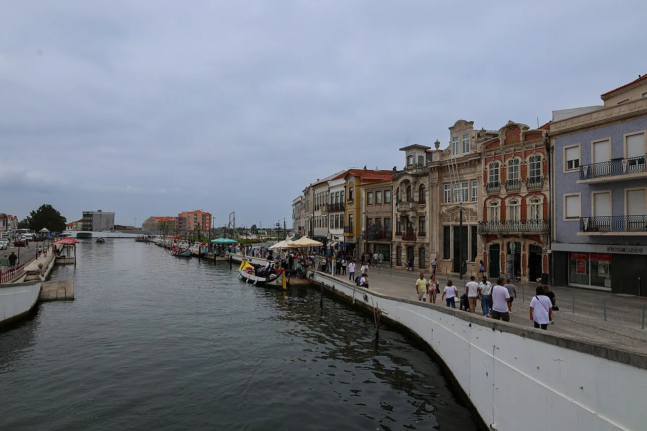 A canal in Aveiro lined with historic buildings and moored boats.