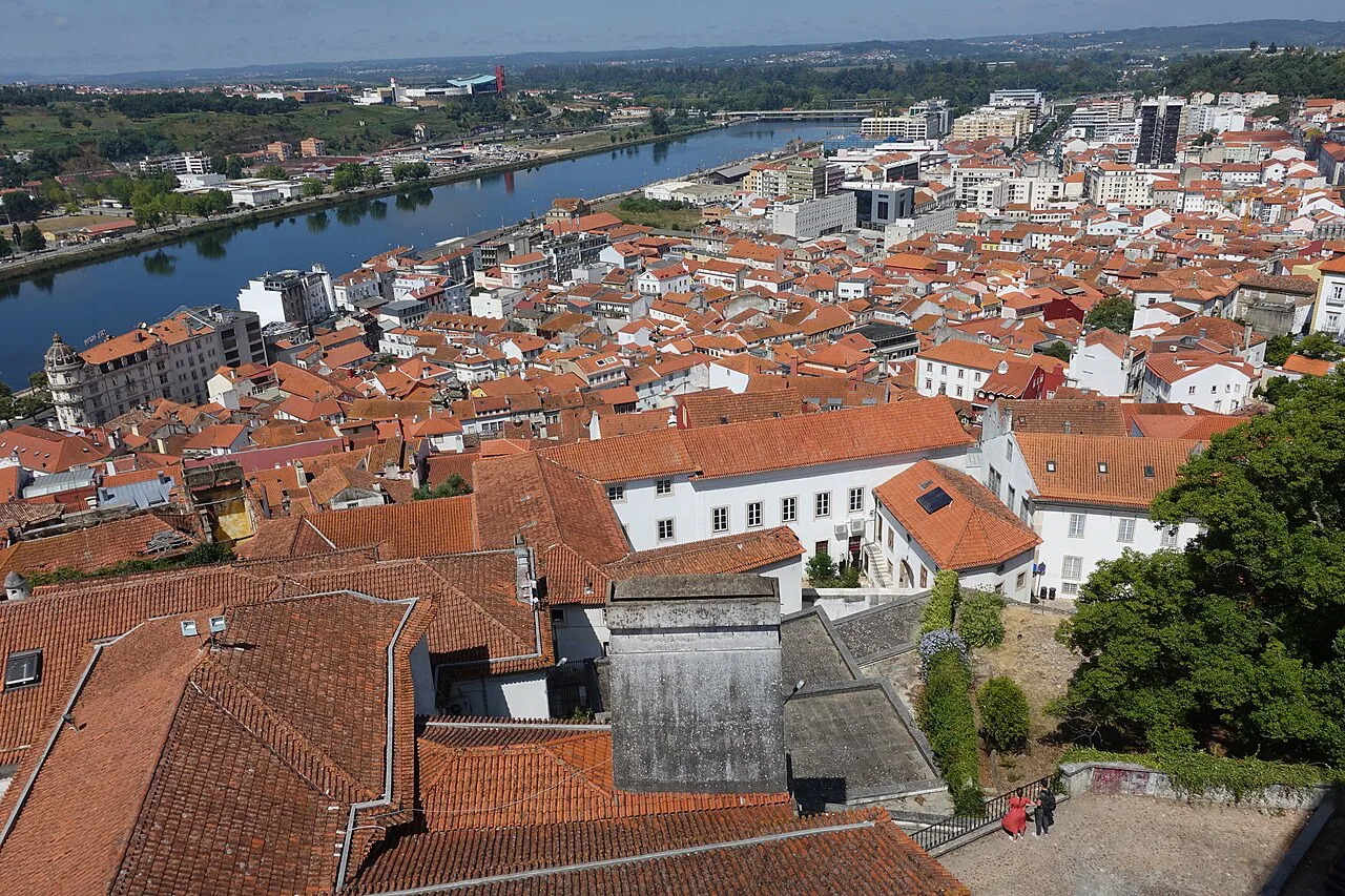 Red-tiled rooftops of Coimbra sloping down towards the river.