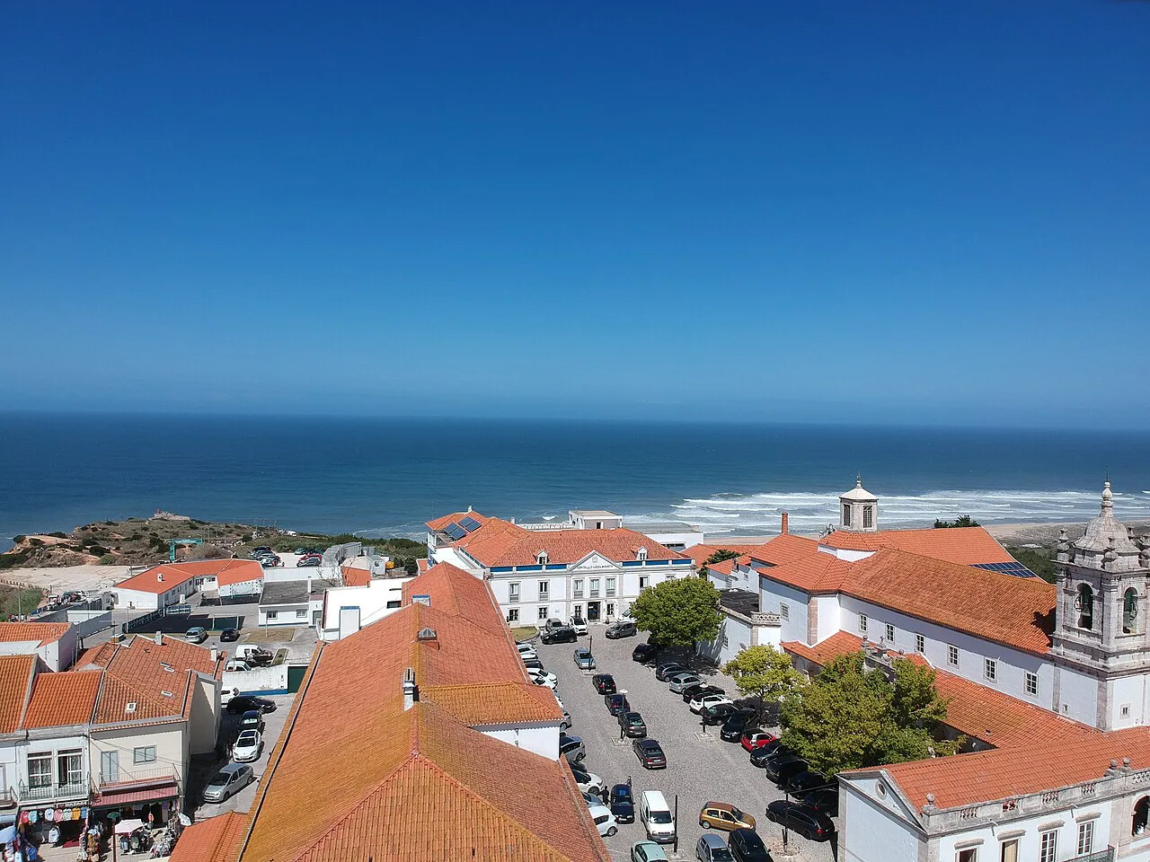 Red rooftops of Nazaré stretching towards the sea.