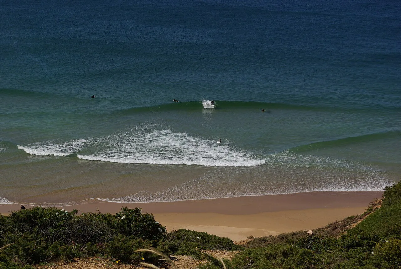 Waves rolling onto a sandy beach near the fortress in Sagres.
