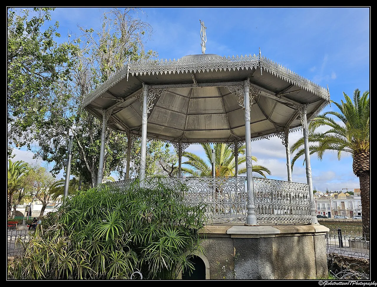 A wrought-iron bandstand among palms in a garden in Tavira.