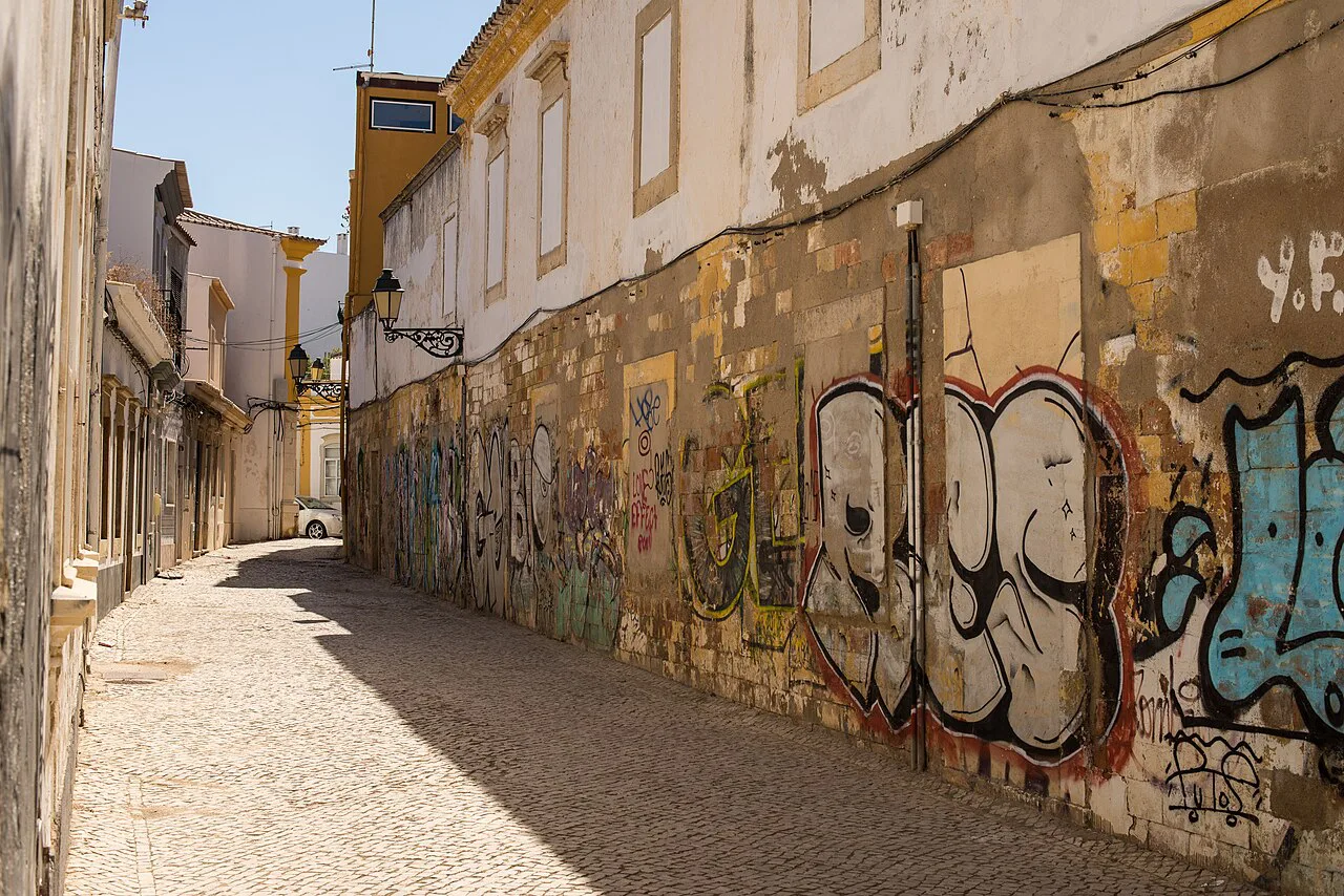 A cobbled side street with graffiti in the old town of Faro.