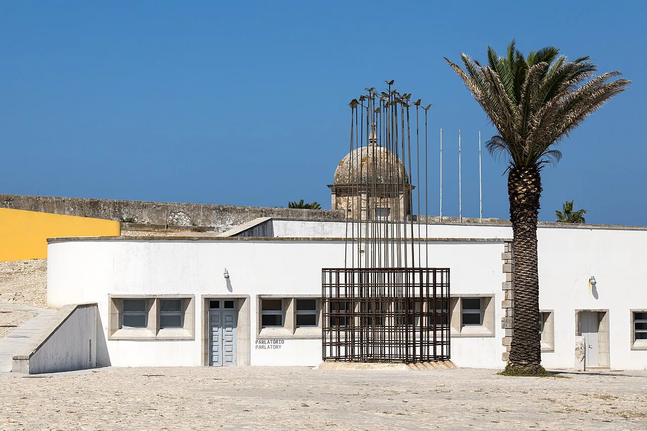 White buildings and a gated entrance at Peniche Fortress.
