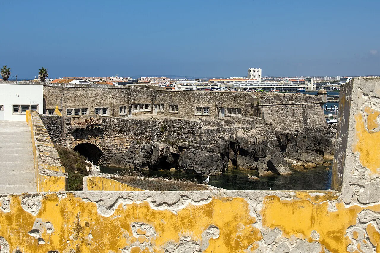 Peniche Fortress walls above the rocks at the water's edge.