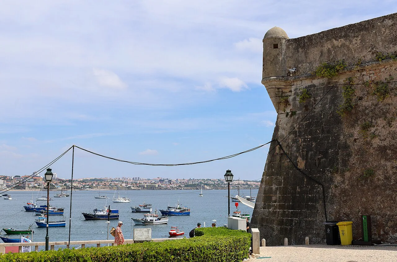 Fortress walls overlooking boats in the bay at Cascais.