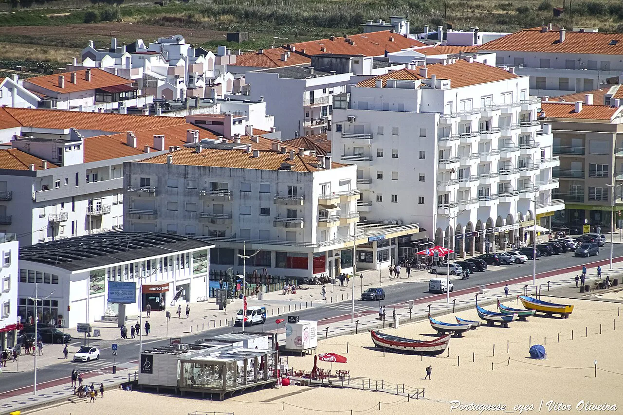 Fishing boats on the beach in front of the seafront buildings of Nazaré.