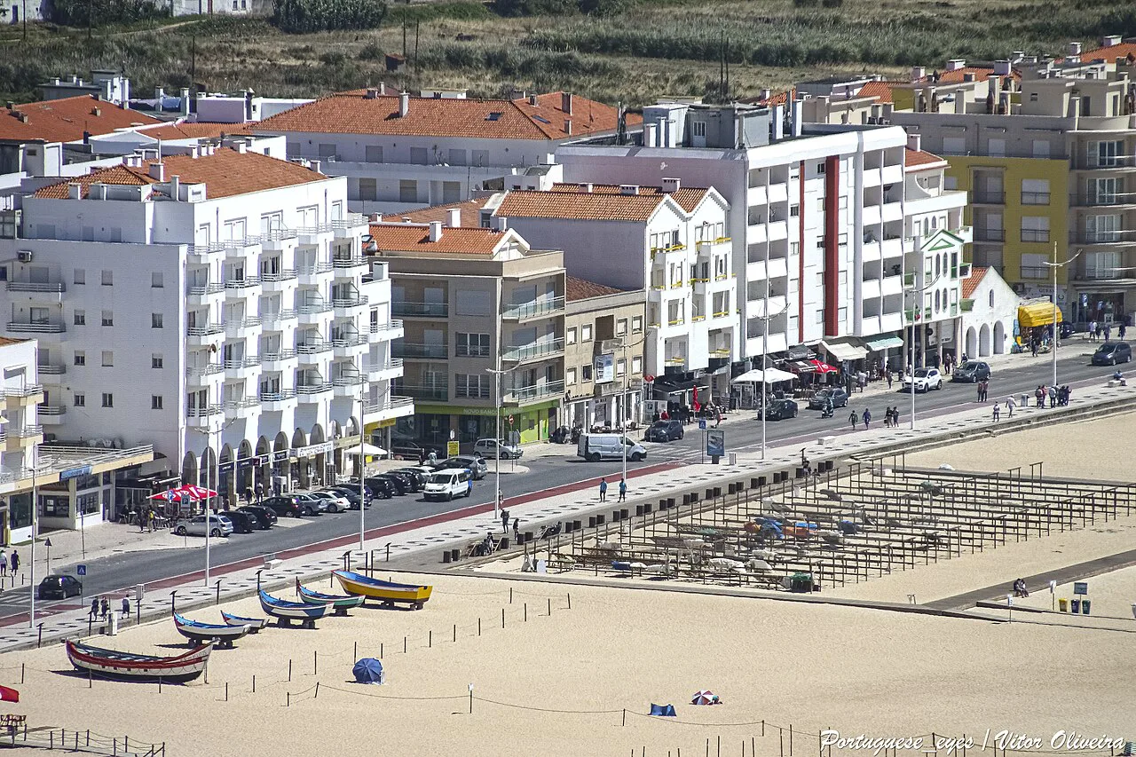 Boats drawn up on the beach below the seafront buildings of Nazaré.