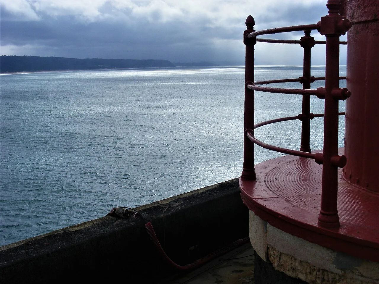 The red railing of the Nazaré lighthouse above the Atlantic.