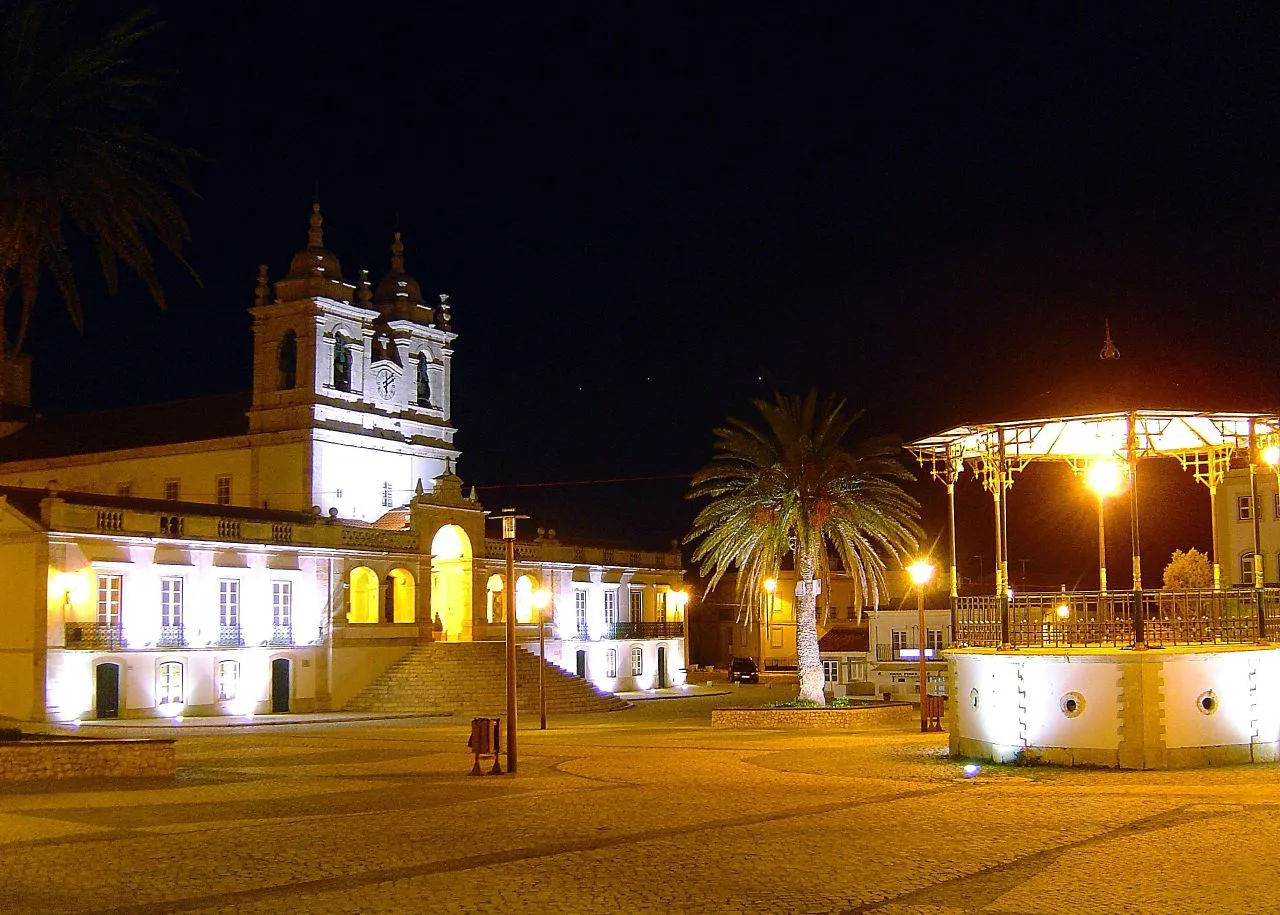The church and bandstand on the square at Sítio in Nazaré at night.