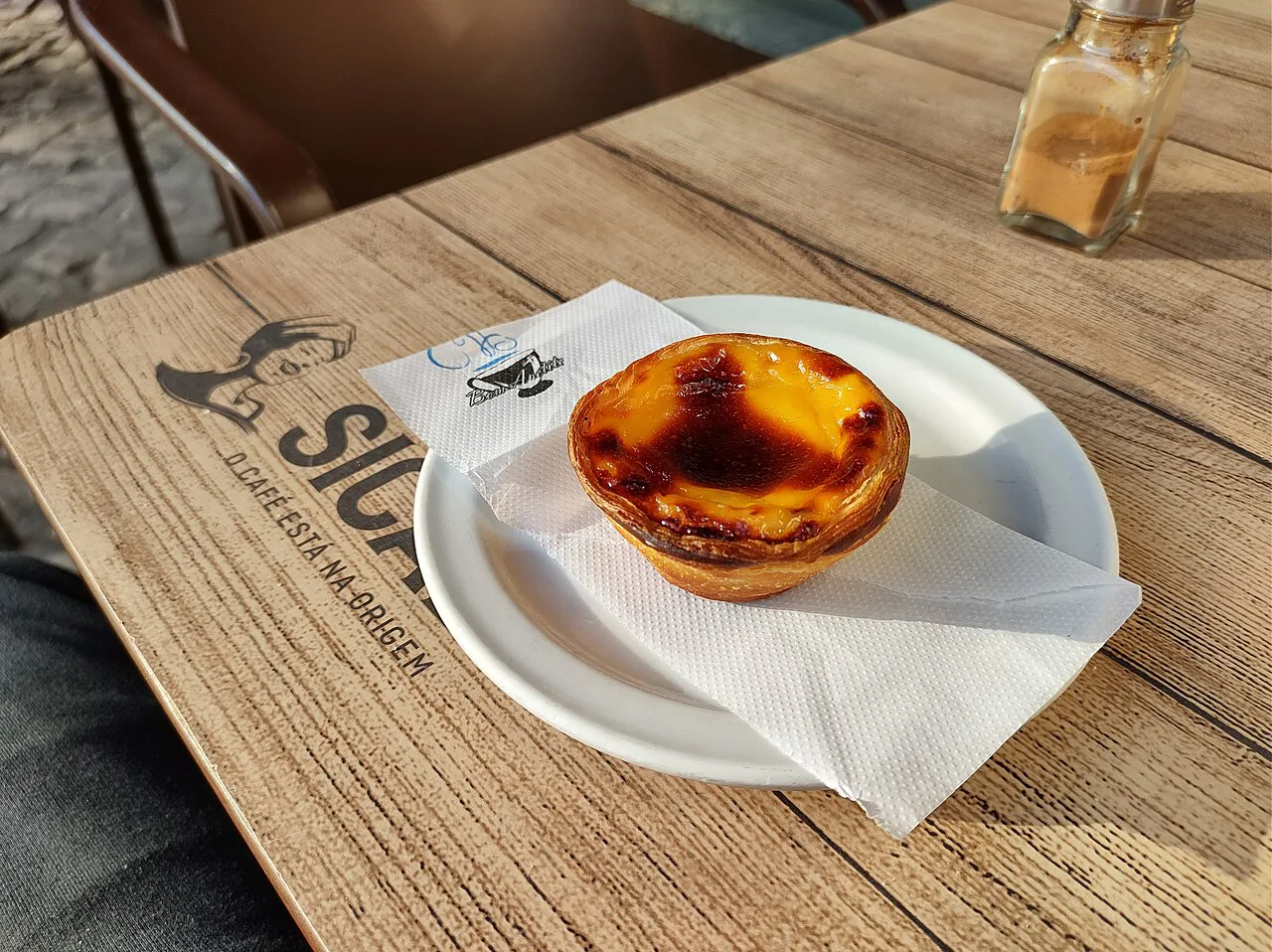 A pastel de nata served on a café table in Nazaré.
