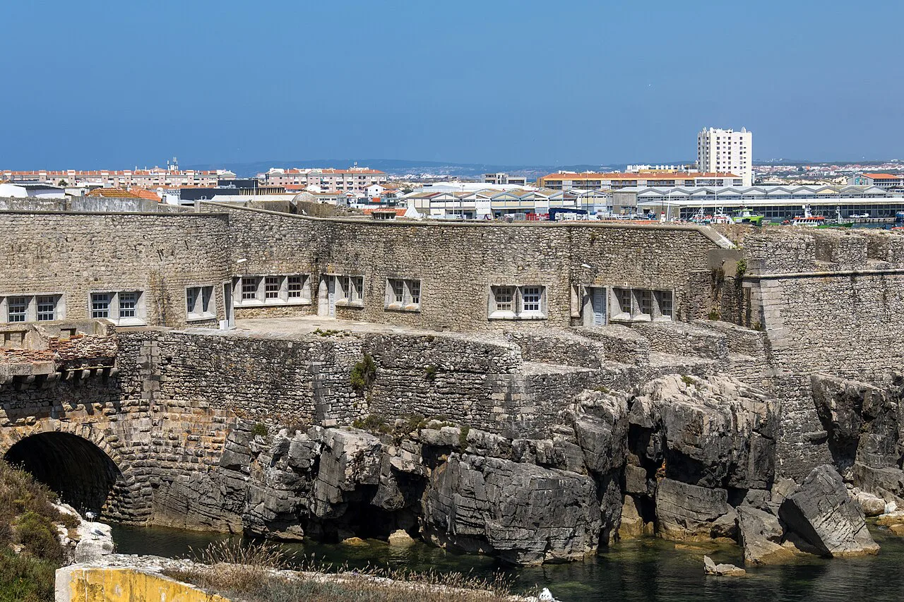 The walls of Peniche Fortress rising above the rocky shore.