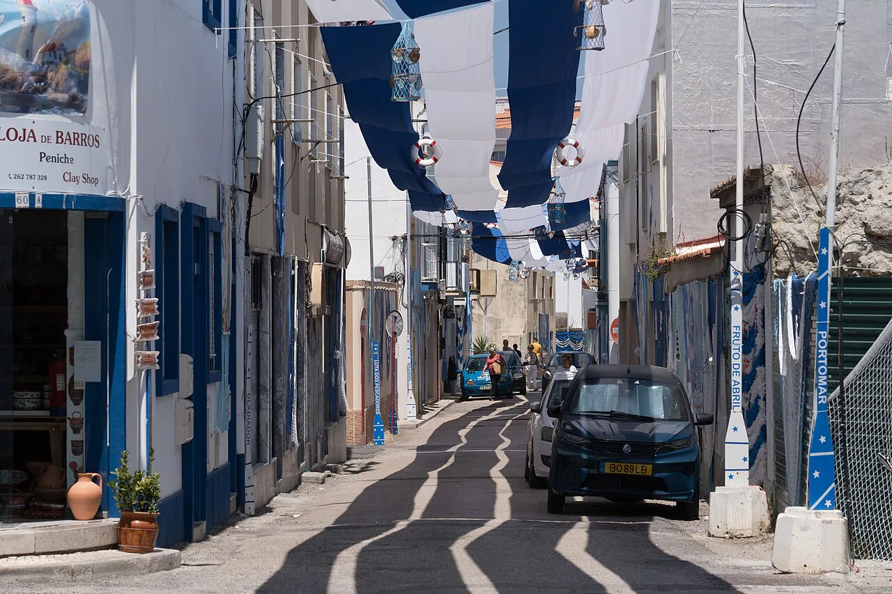 A street in Peniche hung with blue-and-white decorations.