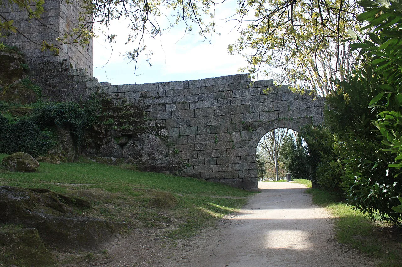 A stone arch and path beside the walls of Guimarães Castle.
