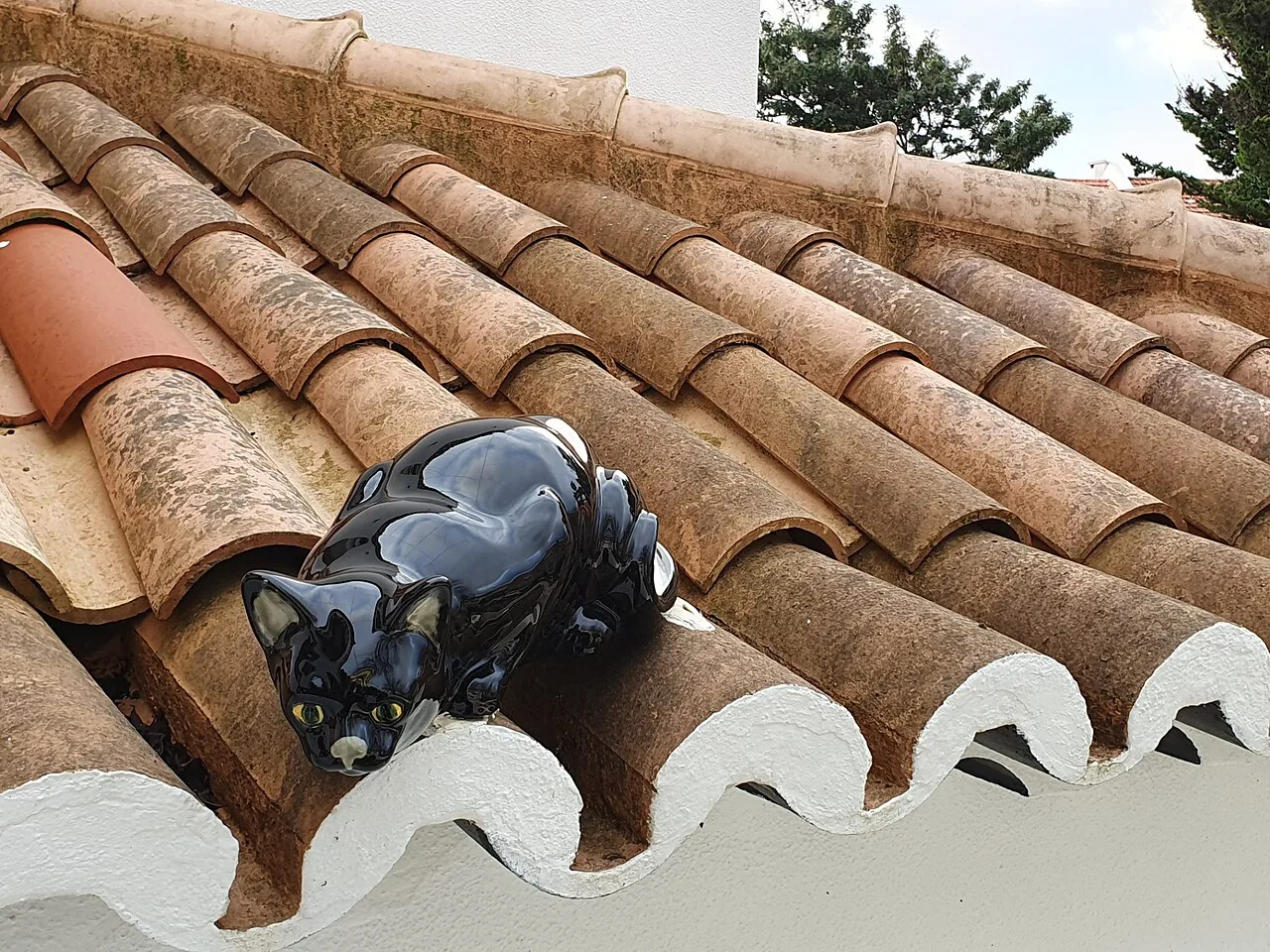 A Bordallo Pinheiro ceramic cat on roof tiles in the garden of the Casa Roque Gameiro, Amadora.